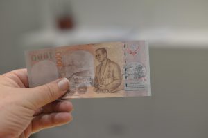 The back of a 1000 Baht banknote, with the image of King Rama IX, H.M. Bhumibol Adulyadej