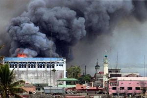 A building in Marawi is set ablaze by air strikes