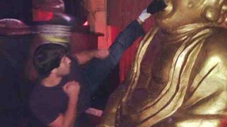 Dagestani muslim kicking Buddha statue in the face.