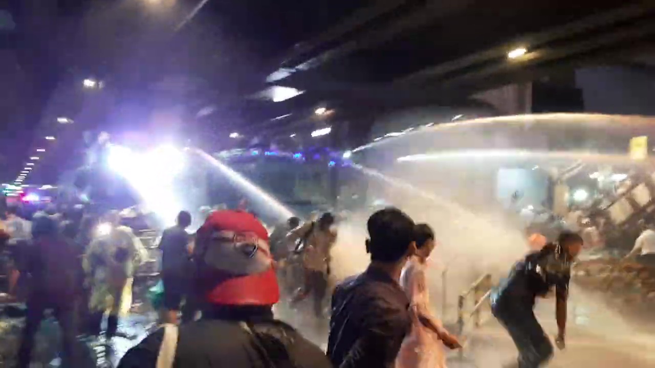 Thai police using water cannon to disperse protesters on Rama I Road in Bangkok, beneath Siam BTS Station, on 16 October 2020