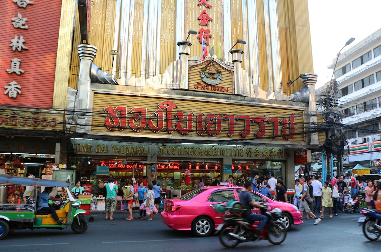 A pink taxi, a tuk tuk and a gold shop on a street in China Town, Bangkok