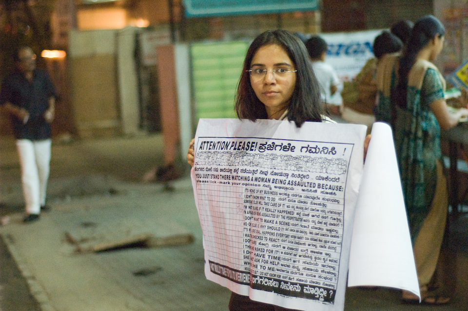Indian girl at Church Street in Bangalore holding a sign to spread awareness about rape