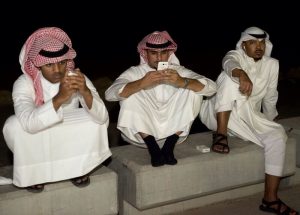 Kuwaiti men look at their cell phones
