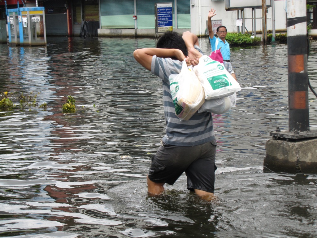 Man carrying bags during Thailand floods in November 2011