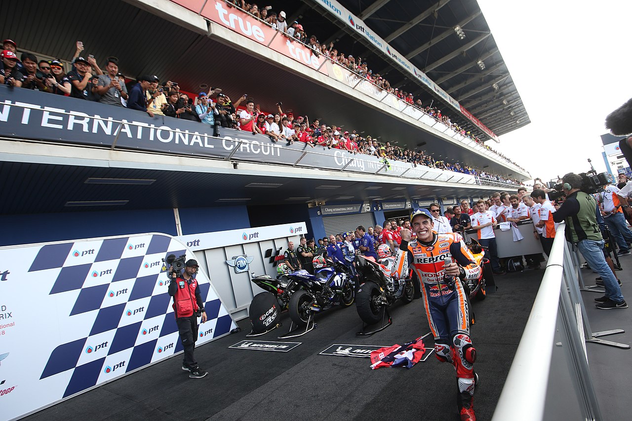 Marc Marquez, running towards the camera as he celebrates in the parc fermé after winning the 2018 Thai Grand Prix at the Chang International Circuit in Buriram.