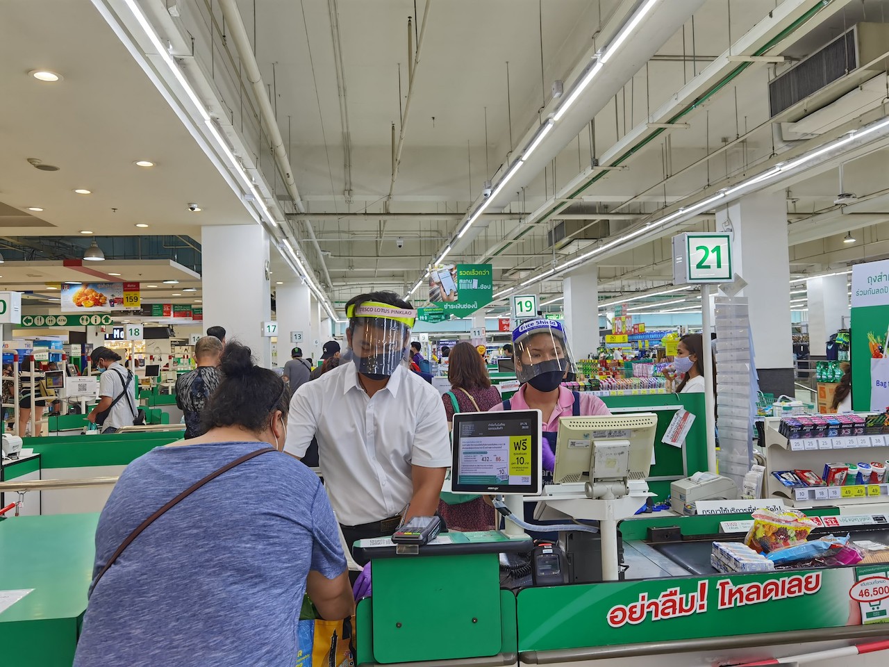 Supermarket cashiers wear masks and face shields to maintain physical distance amid the COVID-19 outbreak in Bangkok