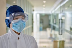 Medical staff wearing a blue face mask and glasses