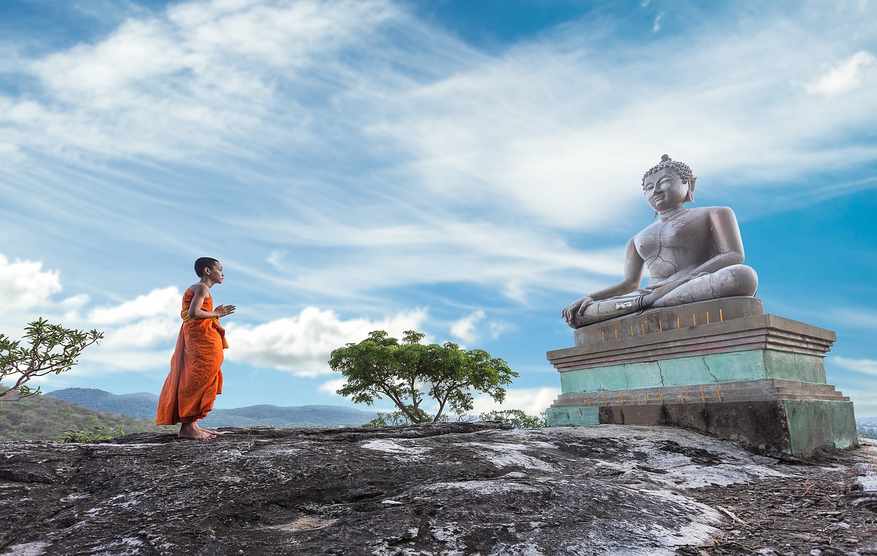 Monk in front of Thai Buddha statue