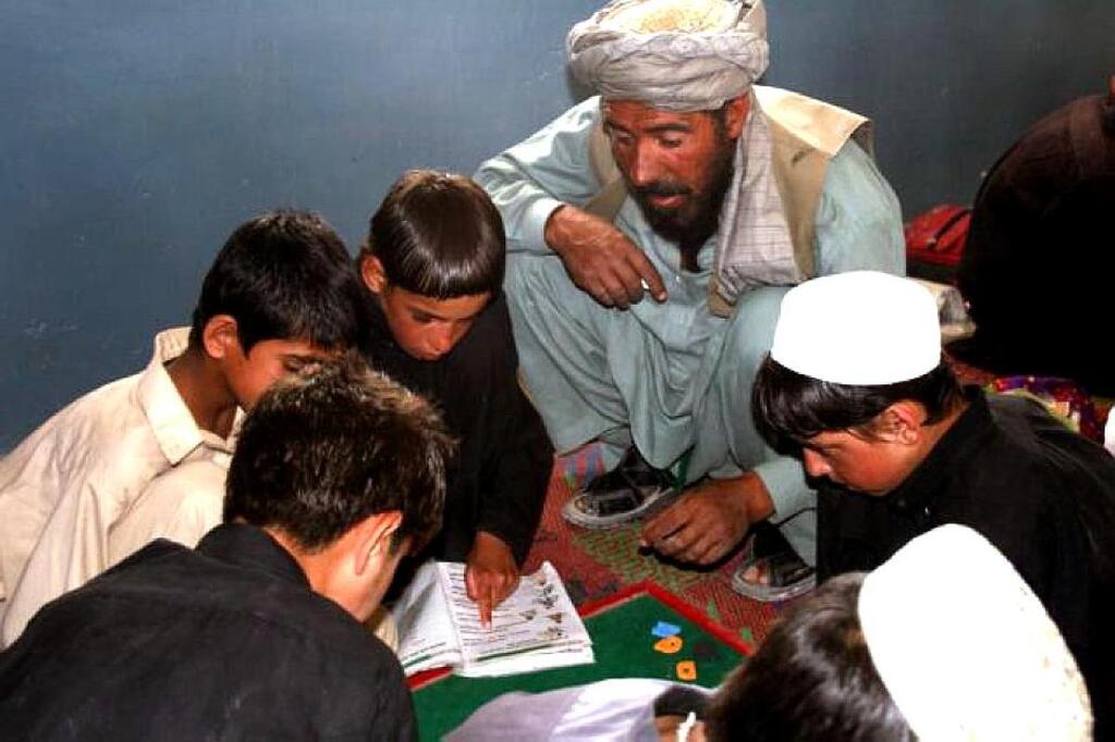 Pakistani teacher giving lessons to children