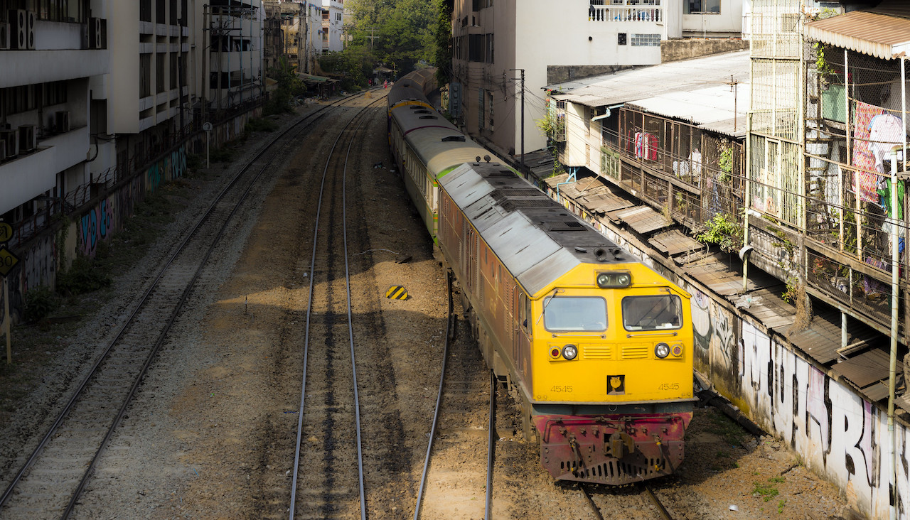 Passenger train rolling through Bangkok, Thailand.
