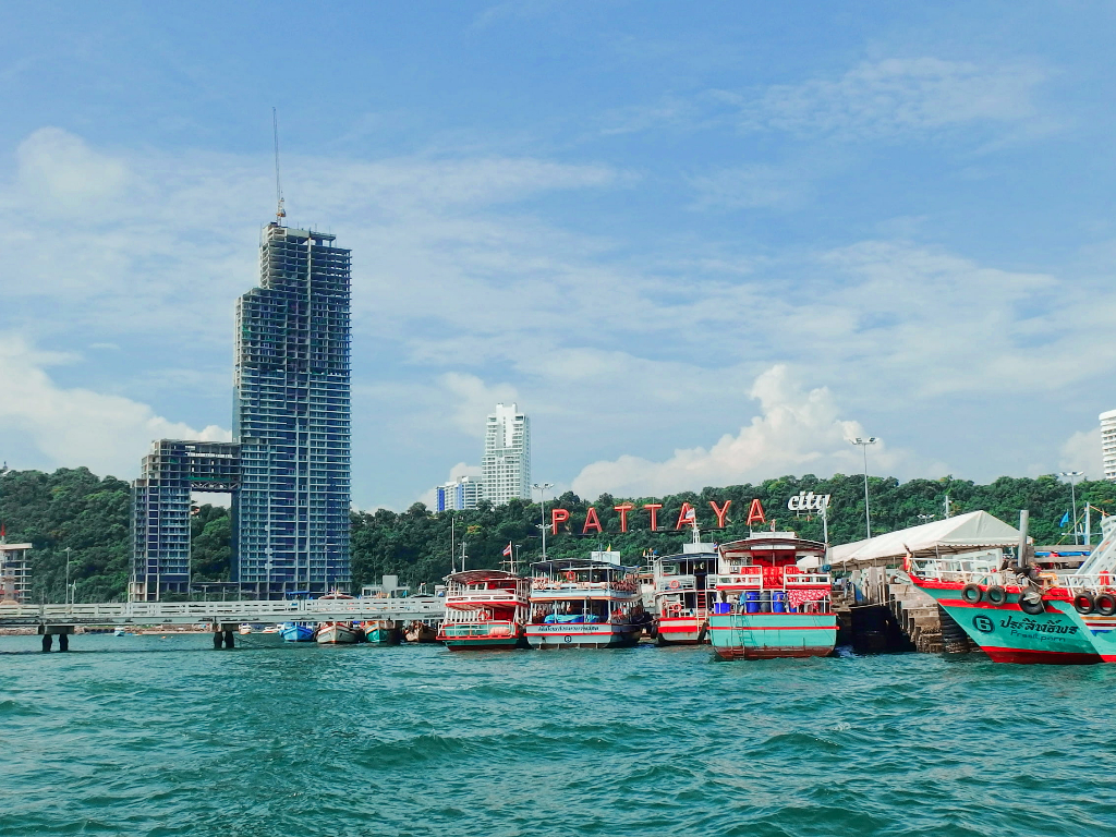 Pattaya City sign and boats at Pattaya pier