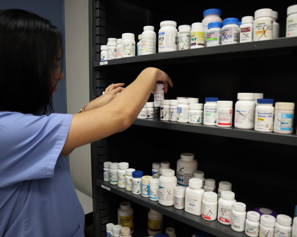Pharmacist restocking medicines