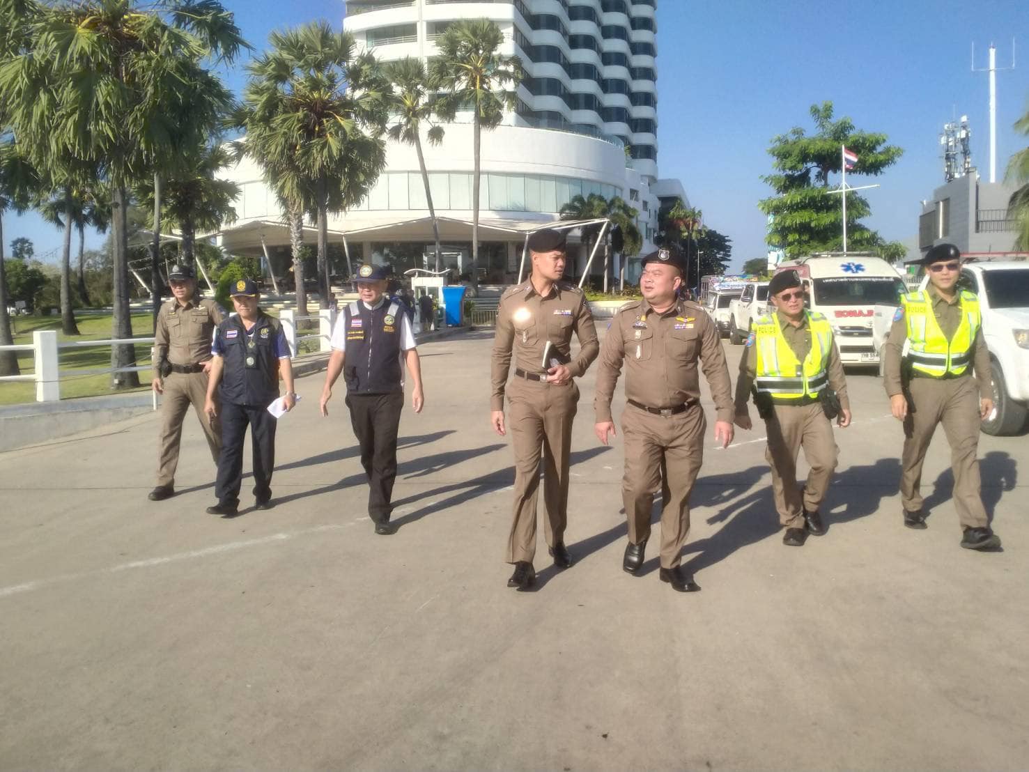 Thai police officers walking near an ambulance in Pattaya.