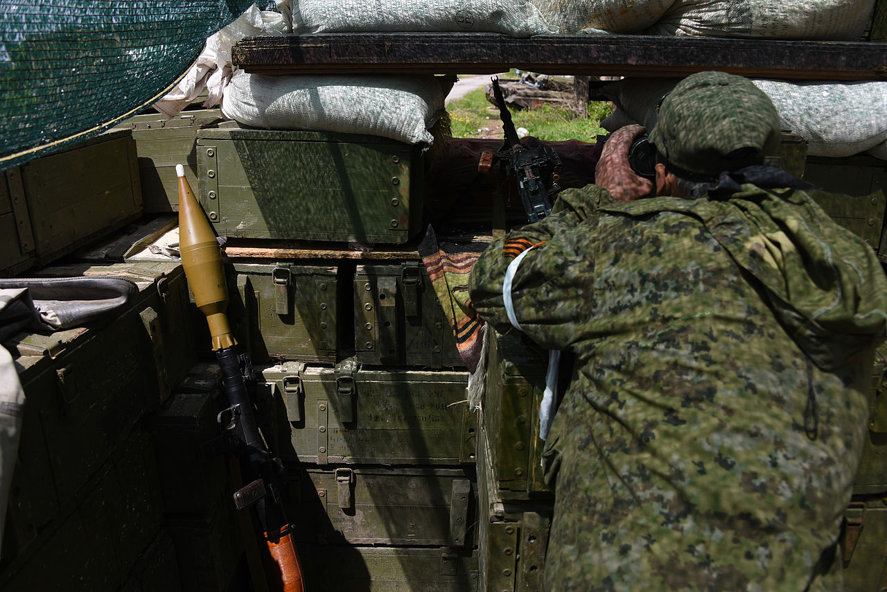 Russian rebel observing Ukrainian army positions though firing port at his position near Donetsk, Ukraine