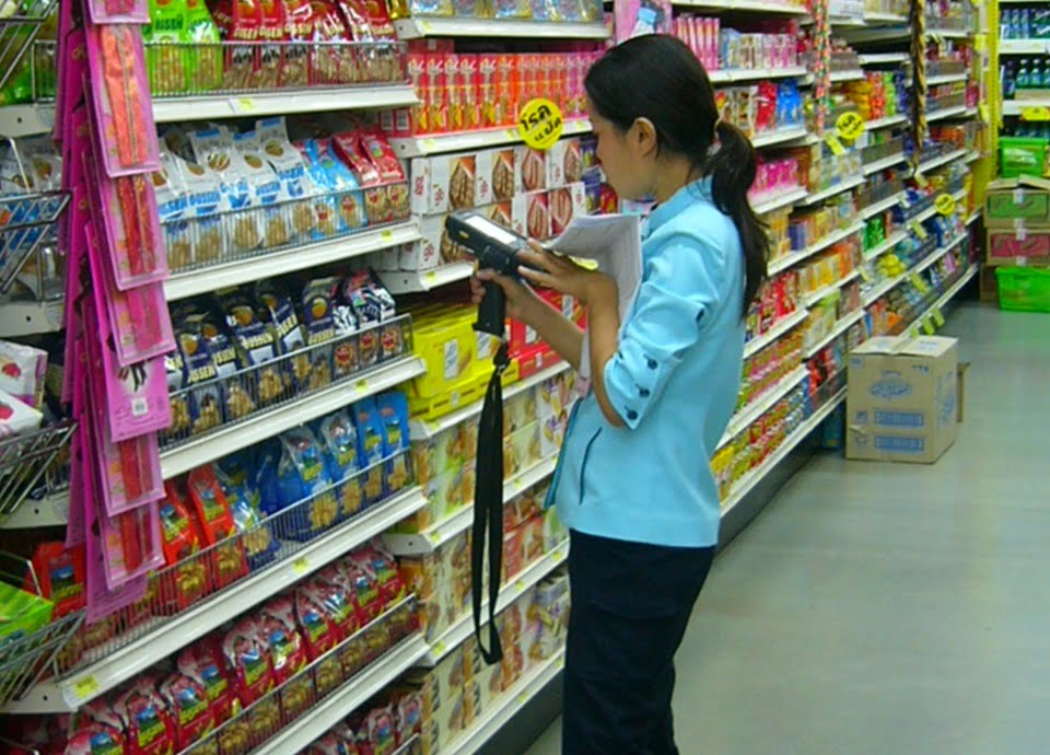 Female clerk doing inventory work in a Tesco Lotus supermarket