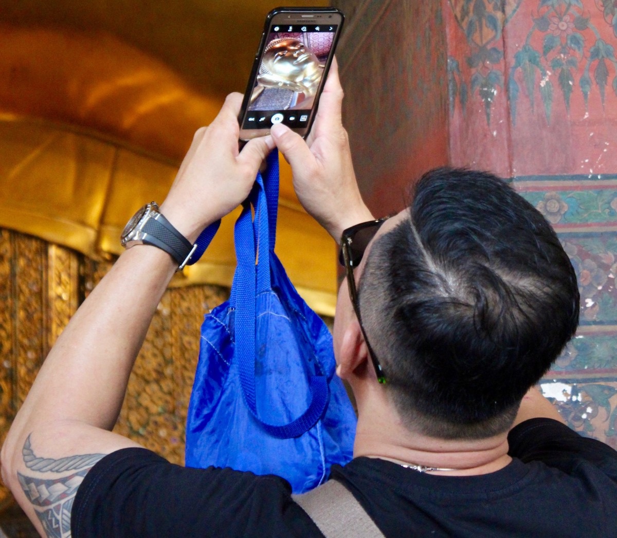 Asian tourist taking a photo at a Buddhist temple