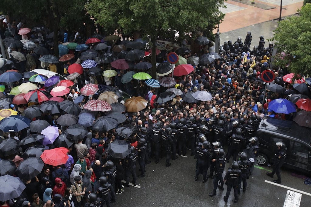 People facing Spanish security forces in Barcelona