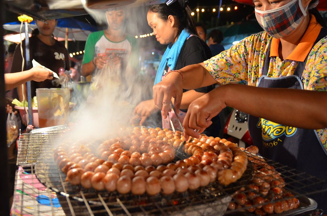 Street food in Thailand. grilled fermented pork balls and sticky rice sausage, originally from the Isan region