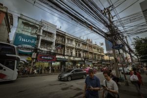 Street in Bangkok with light traffic jam and overhead power cables
