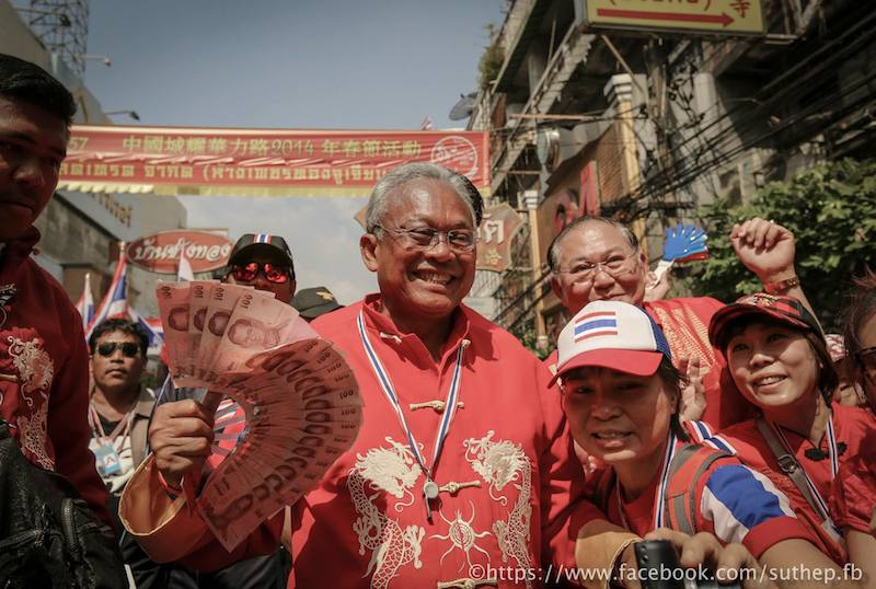 Suthep during the Bangkok Shut Down protests celebrating the Chinese New year, carrying a 100 baht notes fan