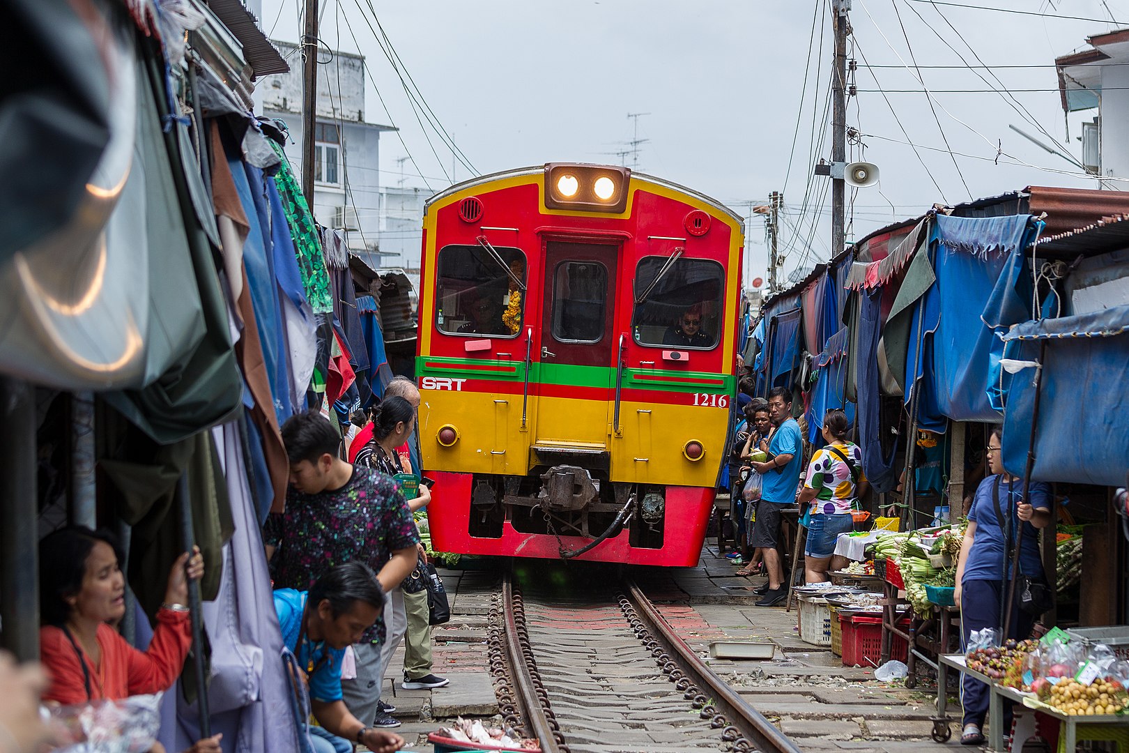 Train running through Talad Rom Hub, also known as Maeklong Railway Market in Samut Songkhram