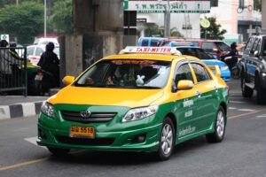 Toyota Saloon sedan taxi driving on the road in Bangkok