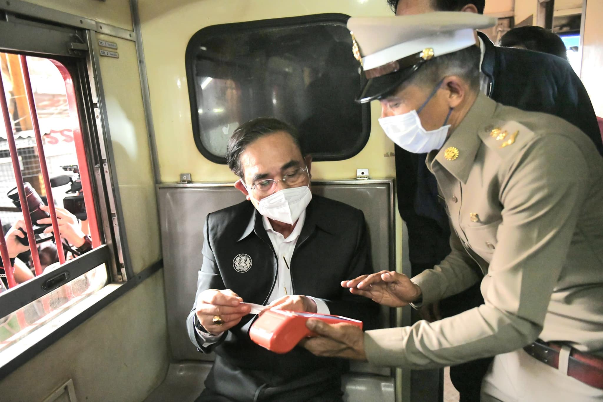 Thai prime minister Prayut Chan-o-cha inside a train with a Thai police officer