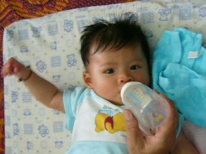 5 months old Thai baby boy sucking milk