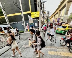 Thai people and passersby walking on Charoen Nakhon Street in Bangkok.