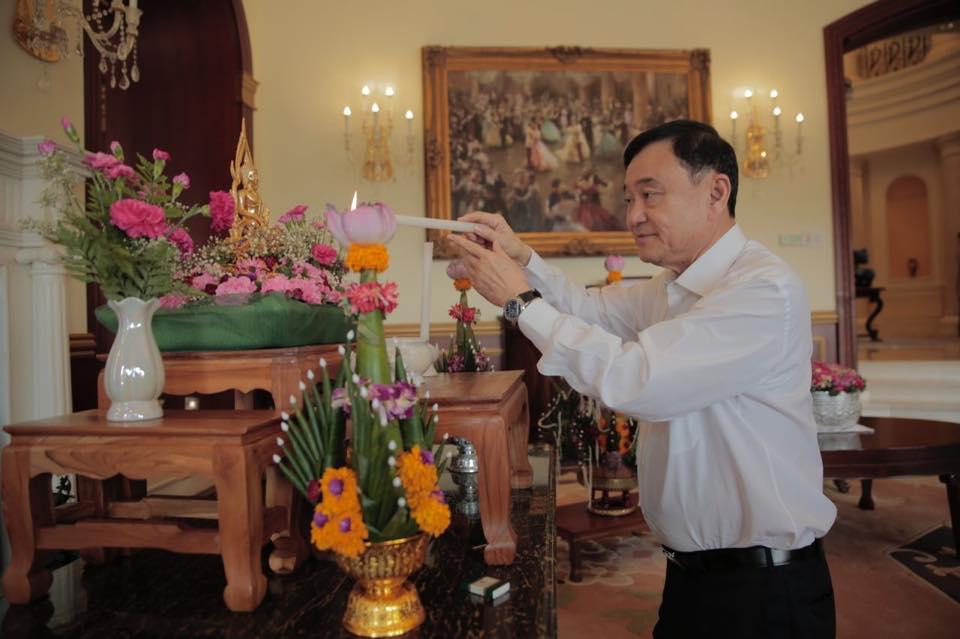 Former Thai PM Thaksin Shinawatra lighting a candle