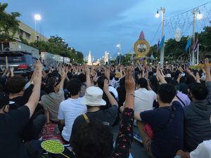 Protesters displaying three-finger salute in front of Democracy Monument in Bangkok