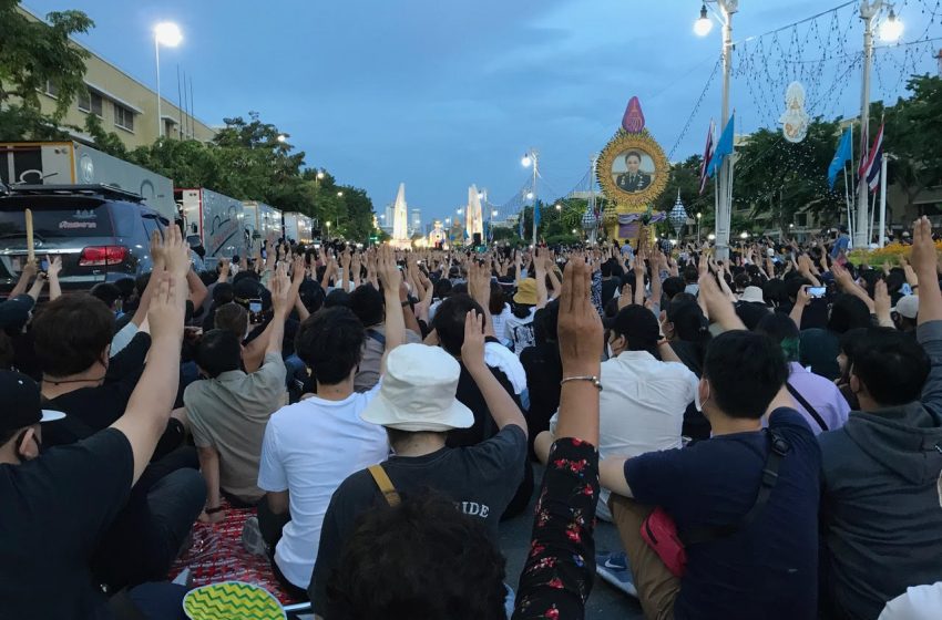 Protesters displaying three-finger salute in front of Democracy Monument in Bangkok