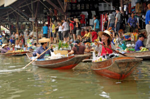Tourists visiting a floating market in Thailand