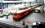 A train crossing a railroad crossing in Bangkok.