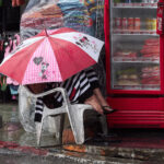 Woman under an umbrella on a rainy day in Patong Beach, Phuket