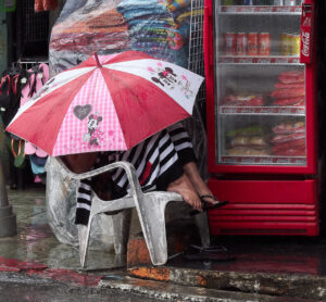 Woman under an umbrella on a rainy day in Patong Beach, Phuket