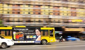 A yellow bus with ads in Bangkok