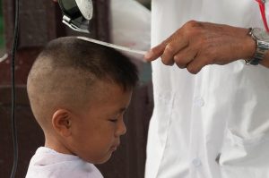 A young boy gets his hair cut in Bangkok