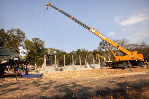 A Thai soldier operates a crane to lower a metal truss onto a multipurpose building during exercise Cobra Gold 2012
