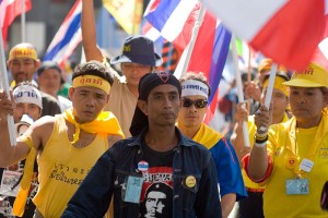PAD Anti-Thaksin protesters walk on Bangkok street wearing yellow t-shirts