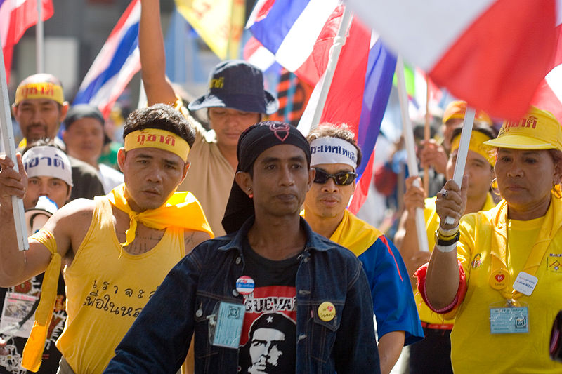 PAD Anti-Thaksin protesters walk on Bangkok street wearing yellow t-shirts
