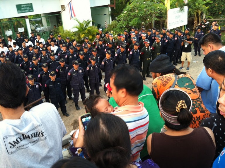 Onlookers watch Thai police and soldiers line up