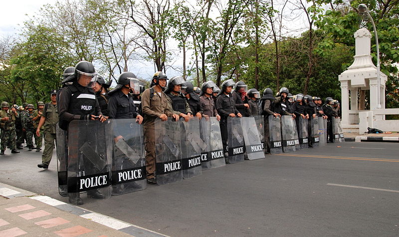 A line of policemen and policewomen equipped with riot shields at Naorawat bridge in Chiang Mai