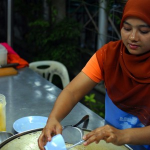 Muslim woman selling roti with banana and egg