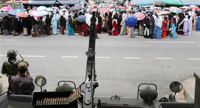 Thai soldiers confront with protesting Thai-Muslim villagers, top, during a protest outside Ingkhayuth military base in Pattani province, southern Thailand