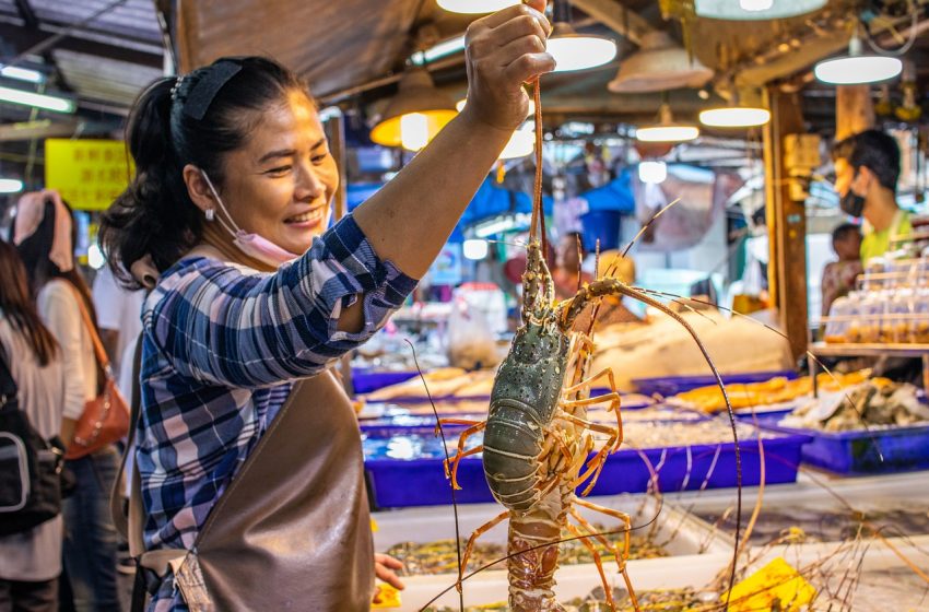 Woman selling seafood at local market in Thailand during the COVID-19 pandemic
